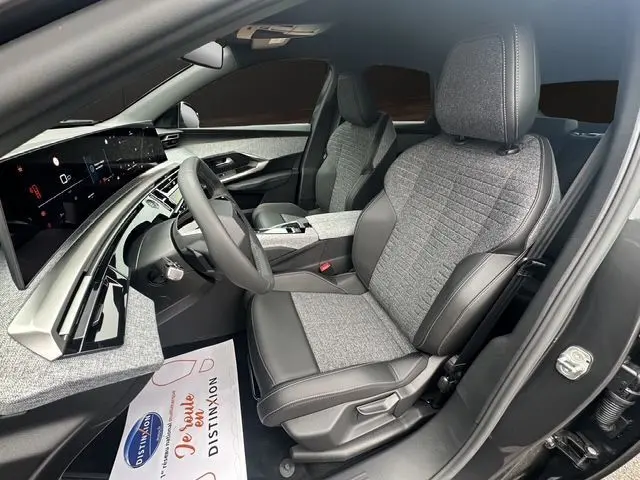 Intérieur avant droit du Peugeot 3008 2025, sièges tissu cuir gris, tableau de bord numérique et volant multifonction.