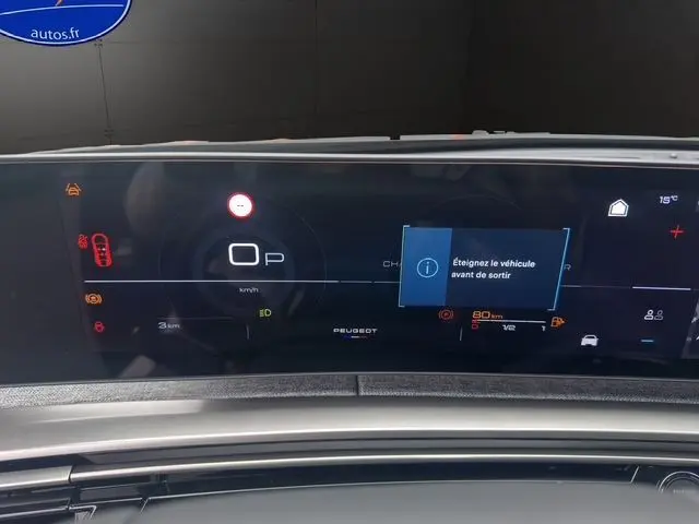 Affichage numérique du tableau de bord du Peugeot 3008 gris titane, avec message d'alerte et indicateurs lumineux.