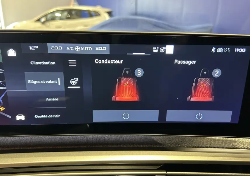 Vue intérieure du tableau de bord du Peugeot 5008 III Hybrid bleu Ingaro, affichant l'écran tactile des sièges et volant chauffants.