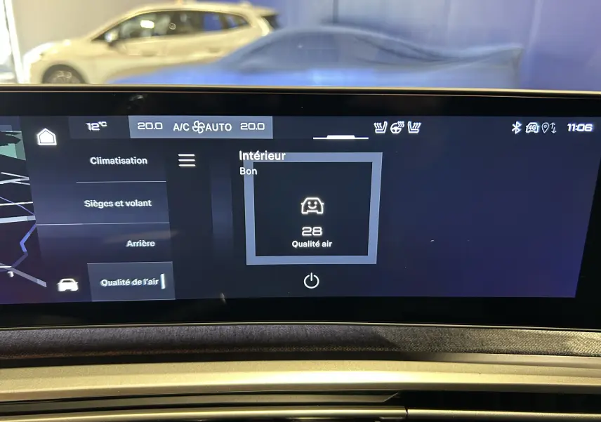 Vue intérieure du tableau de bord du Peugeot 5008 III Hybrid 145 GT avec écran tactile affichant la qualité de l'air et la climatisation.