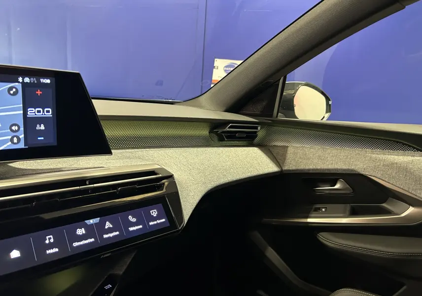 Vue intérieure côté passager du Peugeot 5008 Hybrid 2026, tableau de bord moderne avec écran tactile et finitions tissu grises.