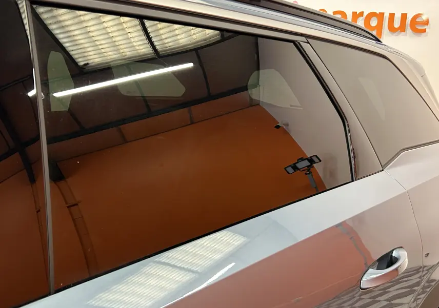 Détail de la porte arrière côté droit d’un Peugeot 5008 Bleu Ingaro avec vitre teintée et poignée intégrée.