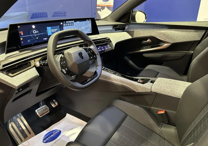 Intérieur avant droit du Peugeot 5008 Hybrid 2026 avec tableau de bord numérique et sellerie cuir gris.