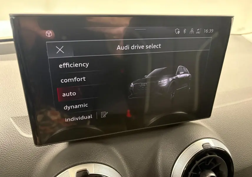 Écran central de l'Audi Q2 35 TFSI 150 S tronic 7 S line 2026 affichant le menu Audi drive select en mode auto.