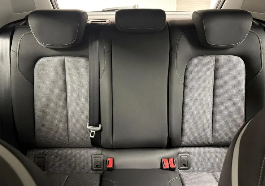 Vue arrière des sièges arrière en tissu gris et noir de l’Audi Q2 35 TFSI S Line 2026, avec ceinture de sécurité centrale visible.
