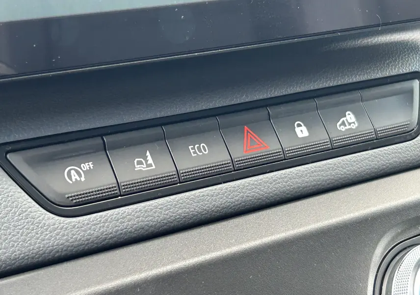 Gros plan sur la rangée de boutons de commande du tableau de bord du Renault Master IV blanc, avec bouton ECO et alerte de danger.
