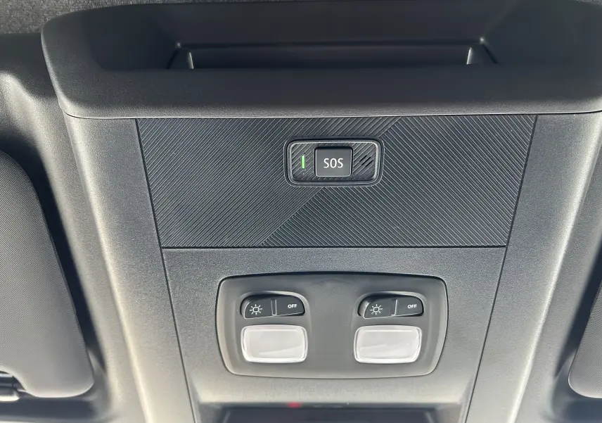 Gros plan sur le plafonnier intérieur noir du Renault Master blanc avec bouton SOS et commandes d’éclairage.