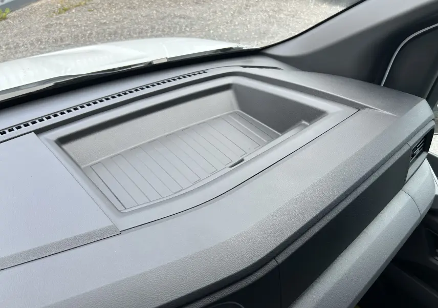 Vue intérieure du tableau de bord gris du Renault Master 2025, mettant en valeur un espace de rangement intégré.