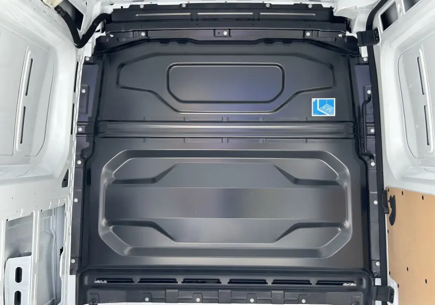 Vue intérieure du plancher arrière noir du fourgon blanc Renault Master IV L2H2, montrant la structure métallique et panneaux latéraux.