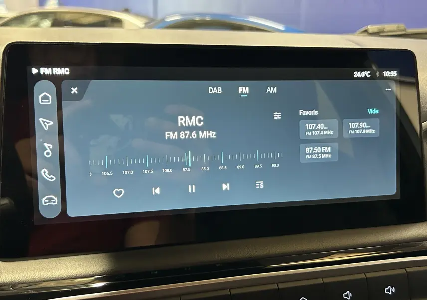 Écran tactile central du MG3 Hybrid+ 195 Luxury affichant la radio FM sur fond noir, intérieur sobre.