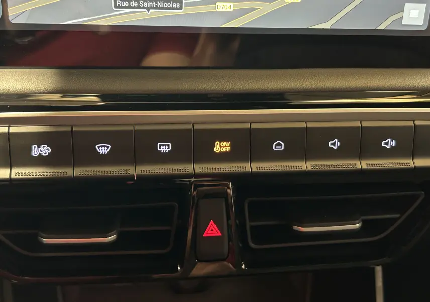 Détail du tableau de bord du MG3 Hybrid+ 195 Luxury 2026 en Pebble Black, montrant les commandes climatisation et bouton de warning rouge.