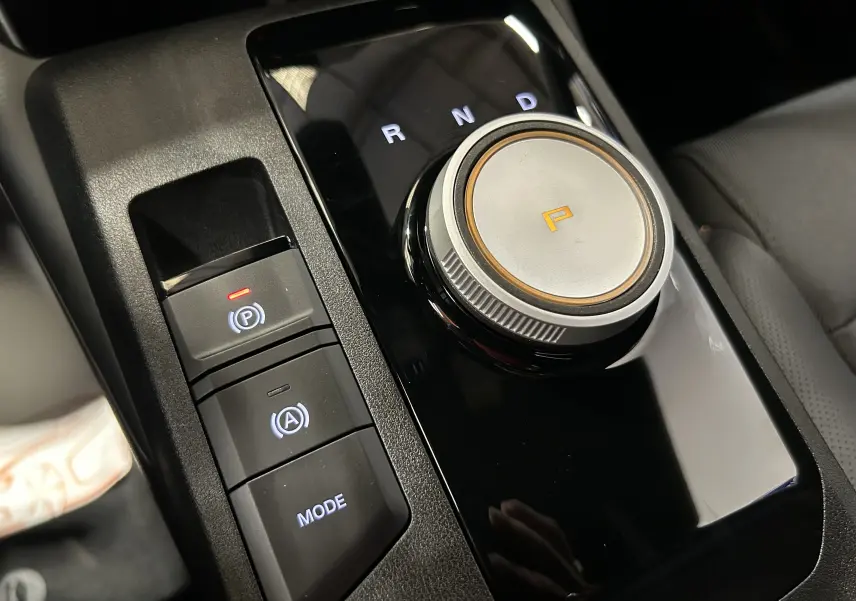 Gros plan sur la molette de boîte automatique et les boutons de frein à main et mode du MG3 Hybrid+ 195 Luxury 2026.
