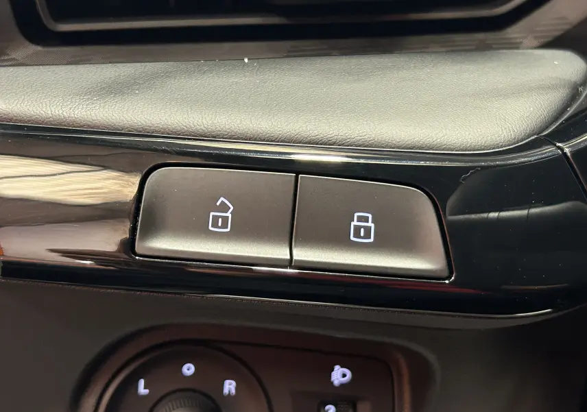 Gros plan sur les boutons de verrouillage centralisé et réglage des rétroviseurs dans l’habitacle noir du MG3 Hybrid+ 195 Luxury.