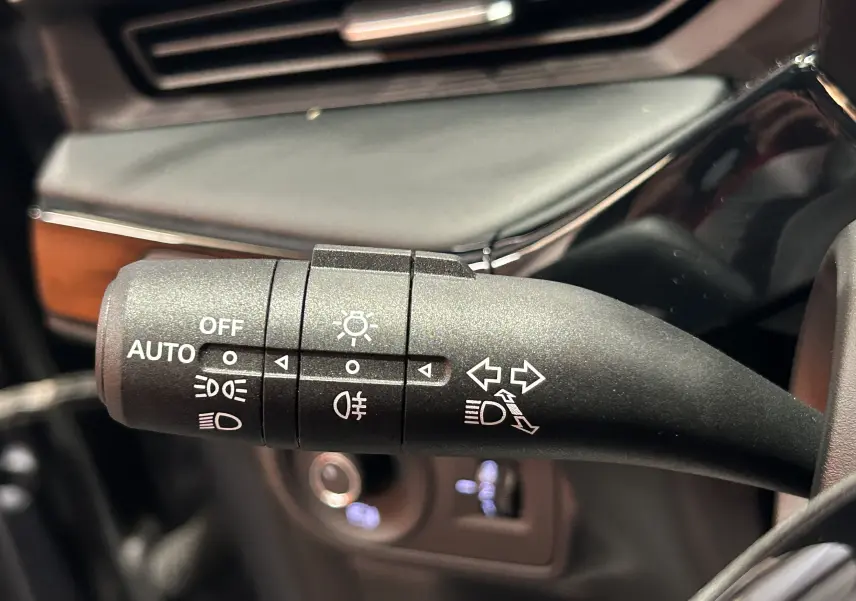 Gros plan sur la manette de commande des phares et clignotants à gauche du volant dans l’habitacle du MG3 Hybrid+ 2026.
