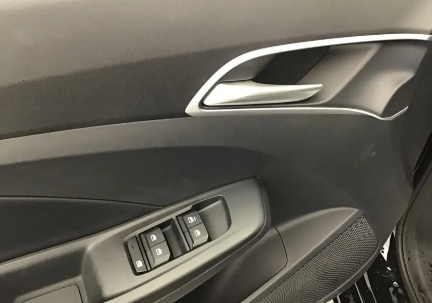 Gros plan sur la porte intérieure côté gauche du MG3 Hybrid+ 195 Luxury 2026, avec commandes de vitres et poignée argentée.