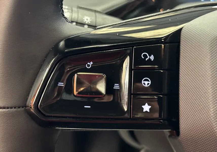 Gros plan sur les commandes noires du volant côté gauche du MG3 Hybrid+ 195 Luxury Pebble Black 2026.