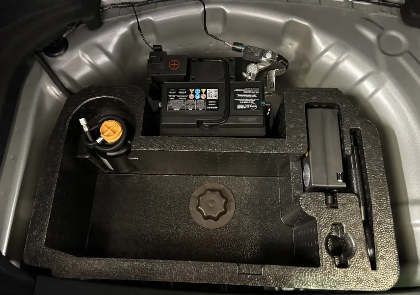 Vue plongeante sur le compartiment batterie et rangement noir dans le coffre du MG3 Hybrid+ 195 Luxury Pebble Black 2026.