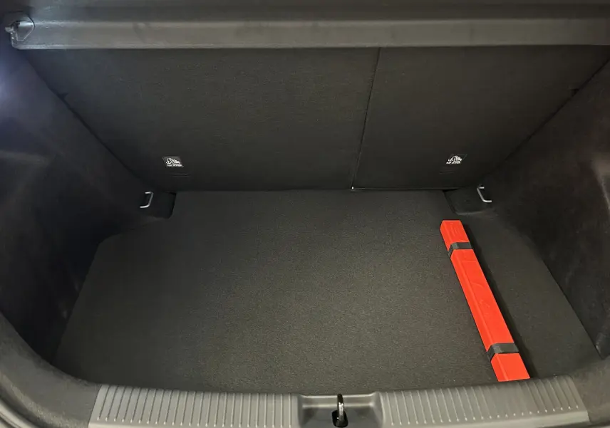 Coffre ouvert de MG3 Hybrid+ 195 Luxury Pebble Black, vue intérieure avec tapis noir et triangle de signalisation rouge.