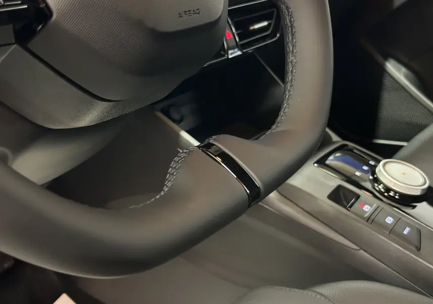 Gros plan sur le volant noir et la console centrale avec molette de la MG3 Hybrid+ 195 Luxury 2026.