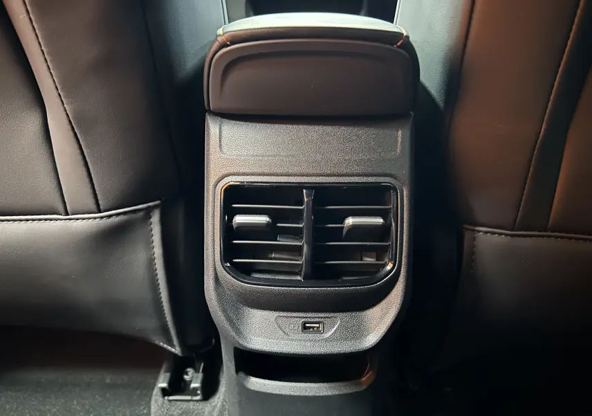 Détail de la console arrière avec bouches d’aération et port USB du MG3 Hybrid+ 195 Luxury Pebble Black 2026.