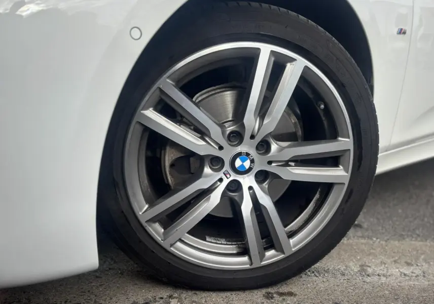 Gros plan sur la jante alliage 18 pouces M Sport d’une BMW Série 2 Active Tourer blanche, côté avant droit.