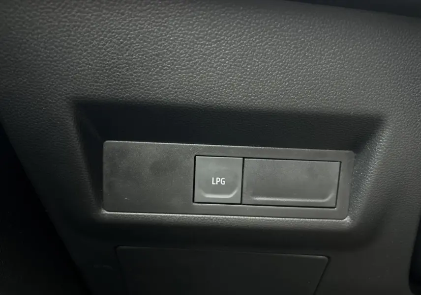 Bouton de commande LPG en gros plan sur le tableau de bord intérieur noir du Renault Captur 2025.