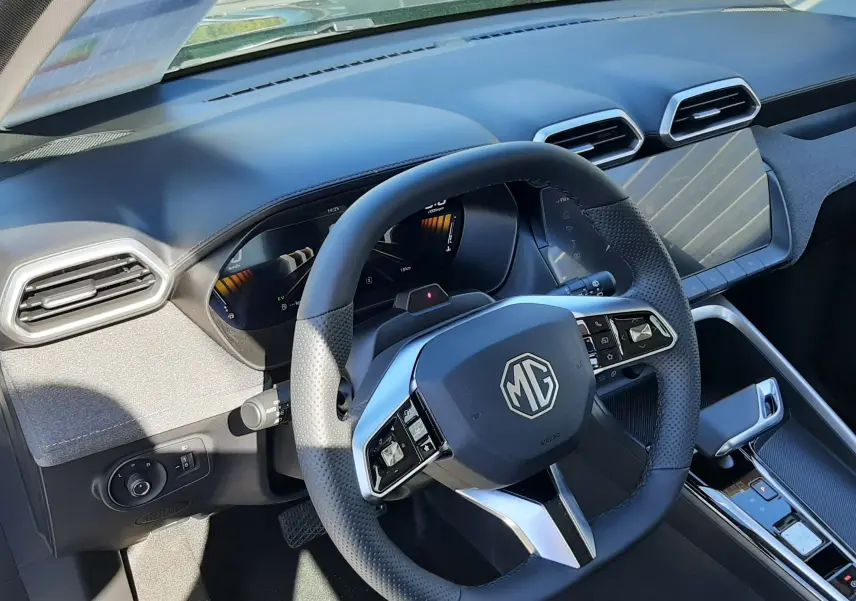 Vue intérieure du poste de conduite du MG ZS 1.5 Hybrid+ 197ch Comfort, volant multifonction et tableau de bord numérique.