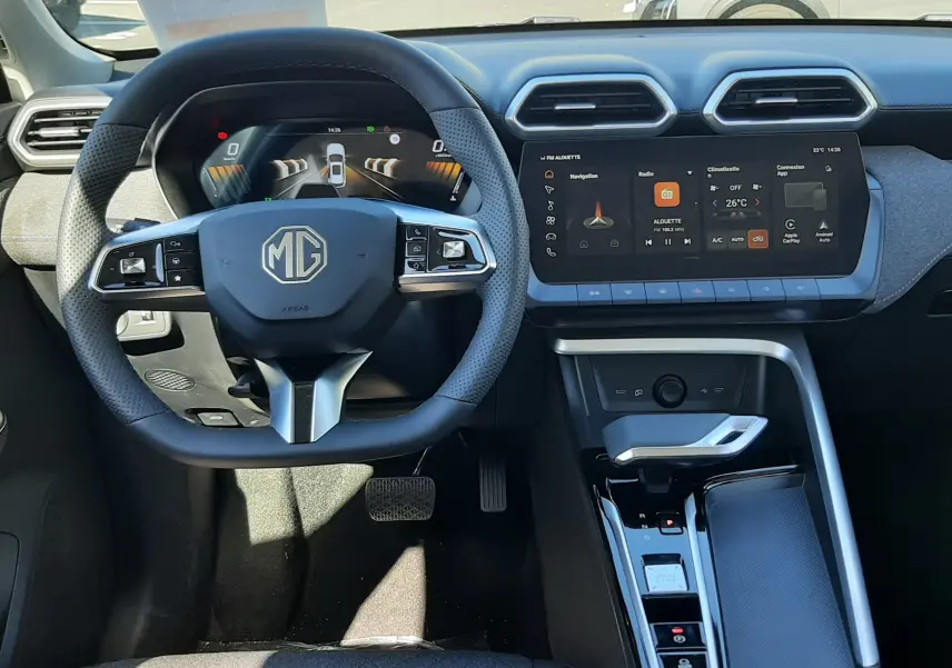 Vue intérieure du tableau de bord du MG ZS 1.5 Hybrid+ 2026, avec volant multifonction et écran tactile central allumé.