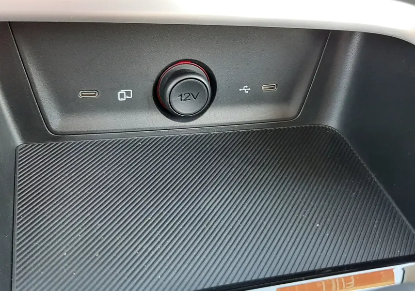 Gros plan sur la console centrale noire du MG ZS 1.5 Hybrid+ 197ch Comfort avec prise 12V et ports USB visibles.