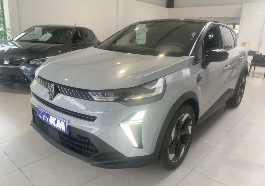 Renault Captur II gris zinc métal vu en 3/4 avant droit, avec feux LED allumés et jantes biton 18 pouces.