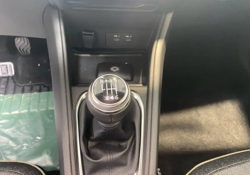 Le levier de vitesses manuel du Renault Captur II 2024 vu de dessus avec console noire et prises USB.