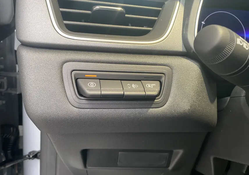 Gros plan sur les commandes de réglage d’éclairage et arrêt auto du moteur à gauche du tableau de bord du Renault Captur gris zinc.