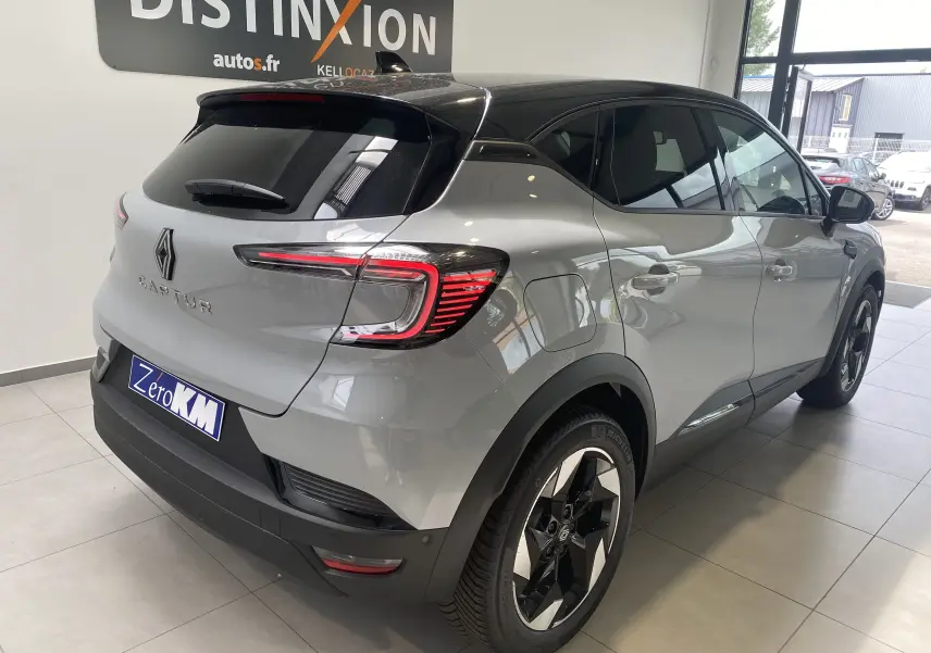 Vue 3/4 arrière droite du Renault Captur II gris zinc métal avec toit noir et jantes bi-ton 18 pouces en showroom.