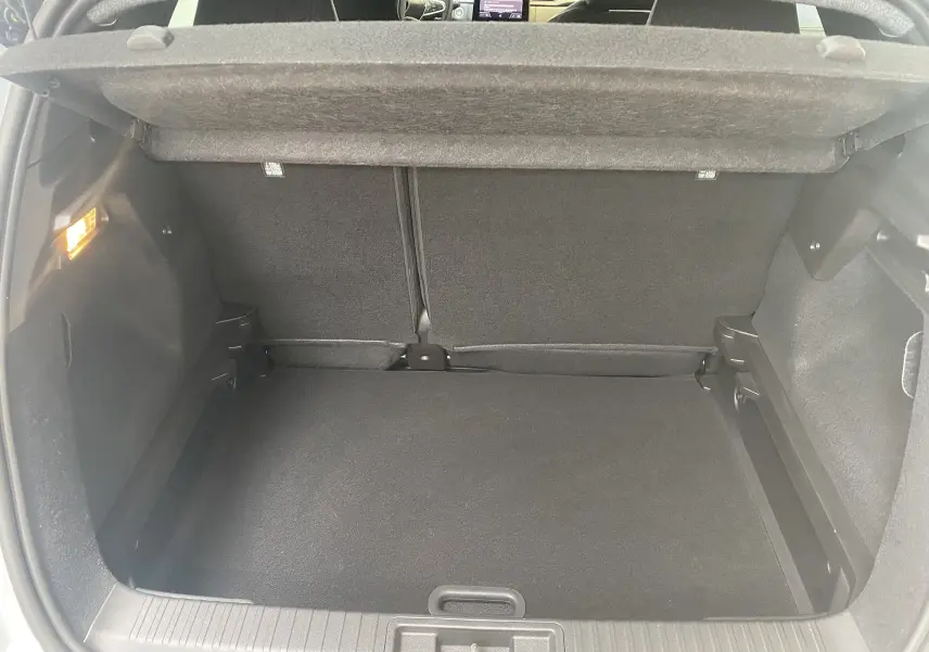 Coffre ouvert du Renault Captur II gris zinc métal, vue intérieure arrière montrant l'espace de chargement vide et la tablette cache-bagages.