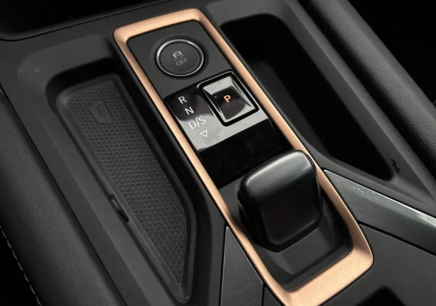 Gros plan sur la console centrale de la CUPRA LEON ST 2025 avec levier de boîte auto et contour cuivré.