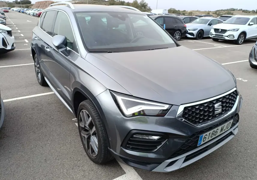 SEAT Ateca gris foncé métal vu en 3/4 avant droit, avec calandre hexagonale et phares LED distinctifs.