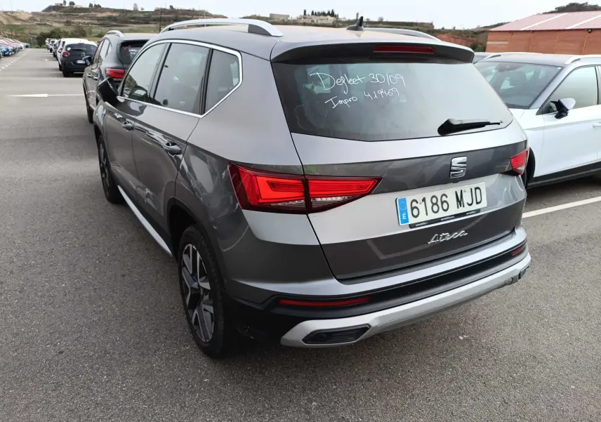 Vue 3/4 arrière droite d'un SEAT Ateca gris foncé métal 2023 avec feux arrière LED et toit ouvrant.