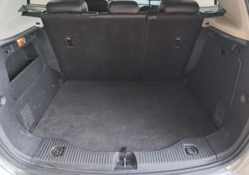 Vue intérieure du coffre ouvert de l'Opel Mokka X gris 2017, montrant un espace de chargement propre et spacieux.