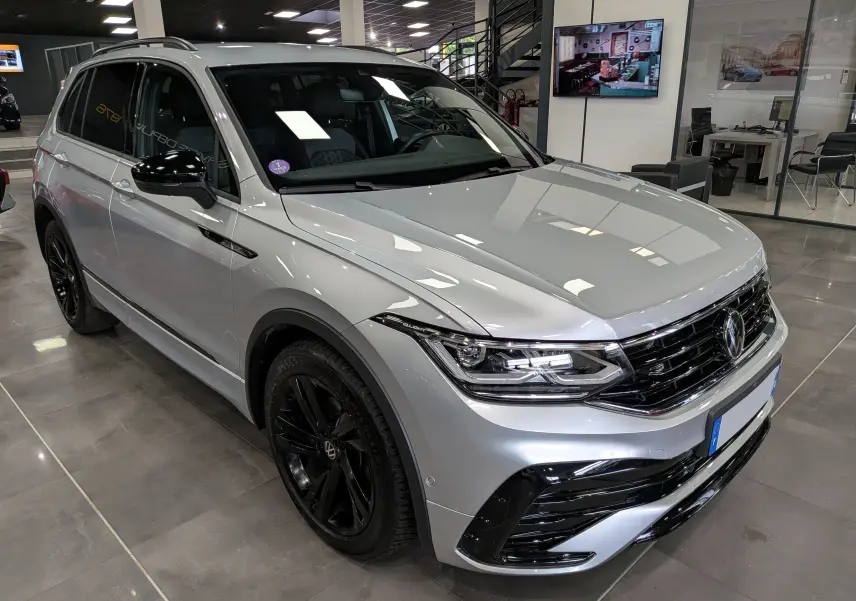 Volkswagen Tiguan 1.5 TSI R-Line reflet d'argent, vue 3/4 avant droit avec jantes noires et calandre sportive.