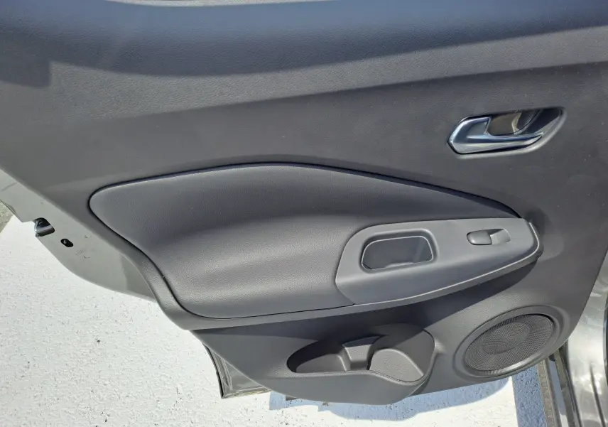 Porte intérieure côté gauche du Nissan Juke Hybrid 143 N-Connecta 2025 en gris squale, avec poignée et haut-parleur intégrés.