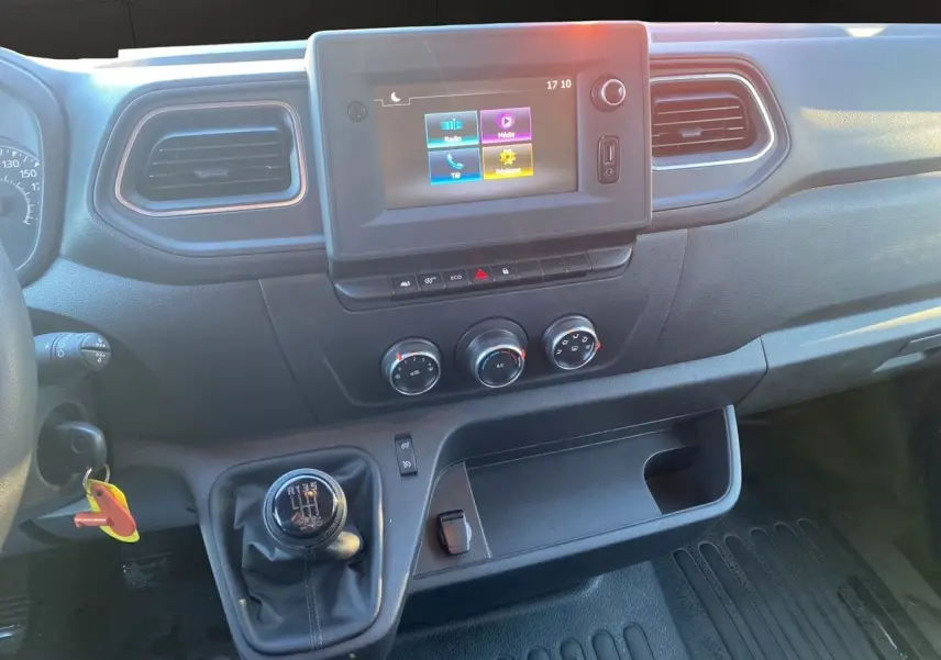 Vue rapprochée du tableau de bord noir du Renault Master Châssis Cabine 2023 avec levier de vitesse manuel et écran tactile central.