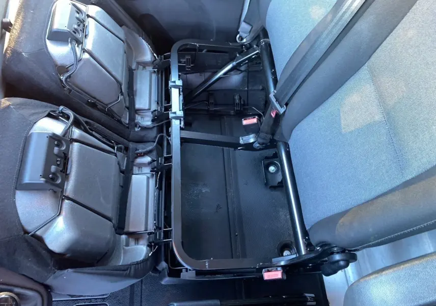 Vue intérieure rapprochée de la banquette arrière rabattue en tissu noir du Renault Master Châssis Cabine blanc 2023.