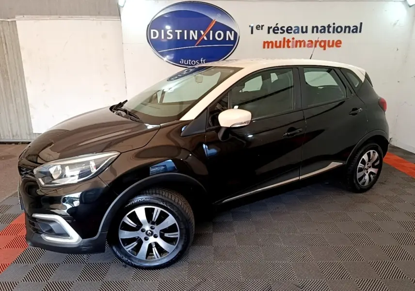 Renault Captur Business TCe 90 noir, vue 3/4 avant droit, avec rétroviseurs blancs et jantes alliage bicolores.