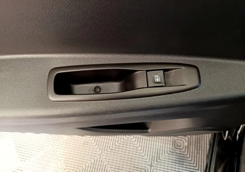 Gros plan sur le bouton de commande de la vitre électrique côté conducteur d’un Renault Captur noir 2018.