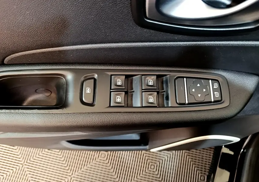 Vue rapprochée des commandes des vitres et des rétroviseurs sur la porte côté conducteur d’un Renault Captur noir 2018.