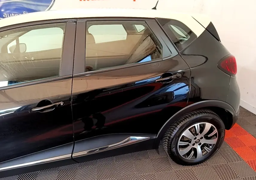 Vue latérale droite du Renault Captur noir avec toit blanc, soulignant les jantes alliage et les poignées de porte noires.