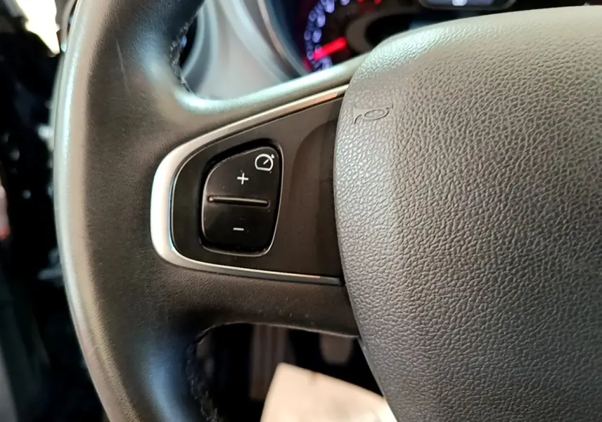 Gros plan sur le volant cuir noir du Renault Captur Business TCe 90, avec commandes de régulateur de vitesse visibles.