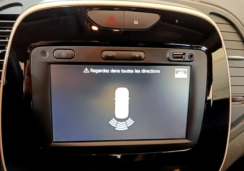 Écran tactile noir du tableau de bord Renault Captur Business 2018 affichant l'alerte de surveillance des angles morts.