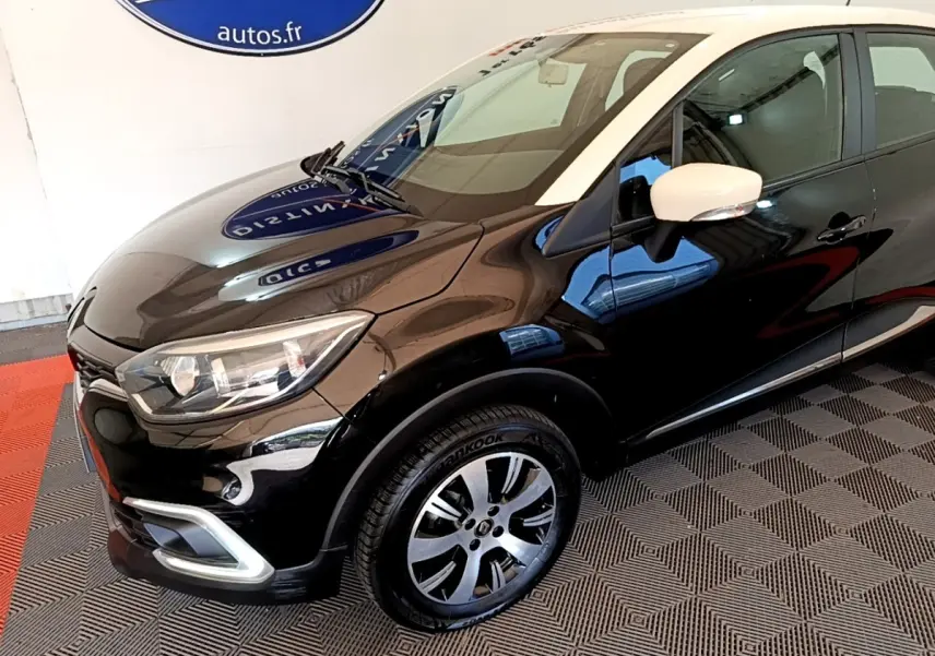 Vue 3/4 avant droit du Renault Captur Business noir avec rétroviseur blanc et jantes alliage bicolores.