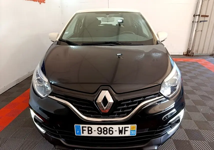 Vue avant d'un Renault Captur Business TCe 90 noir avec feux de jour LED allumés dans un showroom.